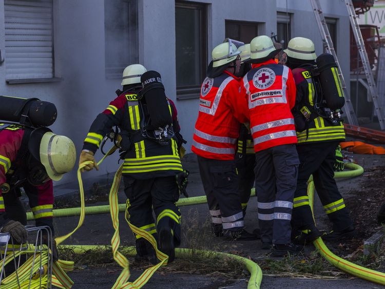 Übung Feuerwehr_07 Feuerwehrleute und DRK-Helfer im Einsatz vor einem brennenden Haus bei einer Übung